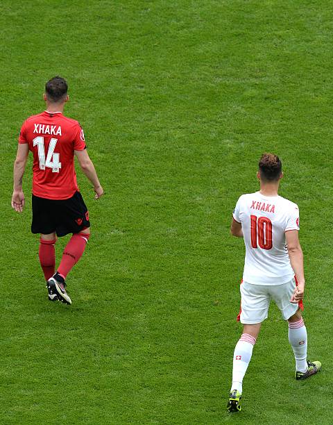 Albania's midfielder Taulant Xhaka (L) walks next to his brother Switzerland's midfielder Granit Xhaka during the Euro 2016 group A football match between Albania and Switzerland at the Bollaert-Delelis Stadium in Lens on June 11, 2016. / AFP / Denis CHARLET 