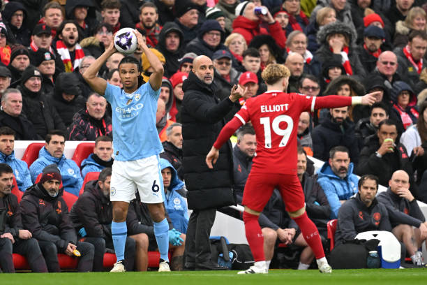LIVERPOOL, ENGLAND - MARCH 10: Pep Guardiola, Manager of Manchester City, gives the team instructions as Nathan Ake of Manchester City prepares to take a throw-in during the Premier League match between Liverpool FC and Manchester City at Anfield on March 10, 2024 in Liverpool, England