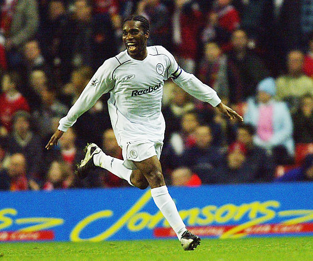 Jay-Jay Okocha best African football players in Premier League history LIVERPOOL, ENGLAND - DECEMBER 3: Jay Jay Okocha of Bolton celebrates after scoring the second goal with a free kick during the Carling Cup fourth round match between Liverpool and Bolton Wanderers at Anfield on December 3, 2003 in Liverpool, England.