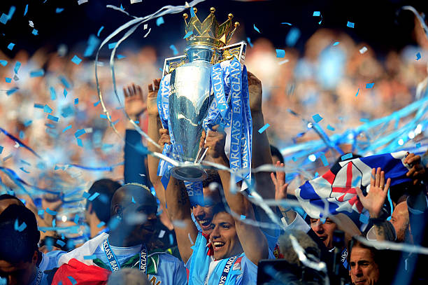 MANCHESTER, ENGLAND - MAY 13: Scorer of the matchwinning goal Sergio Aguero of Manchester City celebrates with the trophy during the Barclays Premier League match between Manchester City and Queens Park Rangers at the Etihad Stadium on May 13, 2012 in Manchester, England.