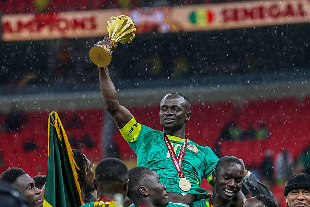 Senegal's forward #10 Sadio Mane holds up the trophy as he celebrates with his teammates after winning the Africa Cup of Nations (CAN) final football match against Morocco at the Prince Moulay Abdellah Stadium in Rabat on January 18, 2026.