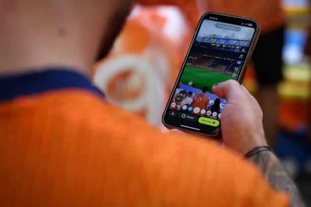 DORTMUND, GERMANY - JULY 10: A fan of the Netherlands posts a video on social media during the pitch recognition during the UEFA EURO 2024 semi-final match between Netherlands and England at Football Stadium Dortmund on July 10, 2024 in Dortmund, Germany.